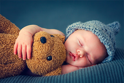 Sleeping baby holding a teddy bear