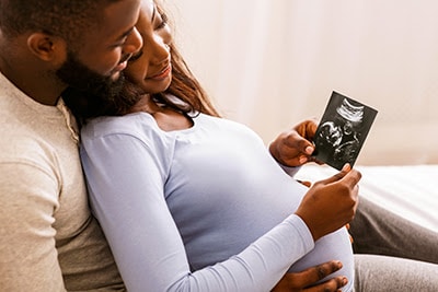 A black couple holding a sonogram image