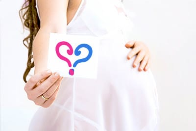 Pregnant woman holding a gender reveal card