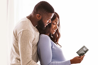 Happy future parents looking at baby ultrosound picture