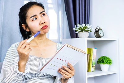 Woman with calendar in her hands, calculating ovulation day