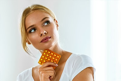 Beautiful Woman Holding Birth Control Pills