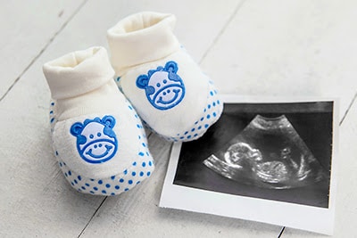 A pair of baby socks and a picture of ultrasound