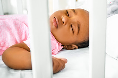 Mom sleeping in shop crib with baby