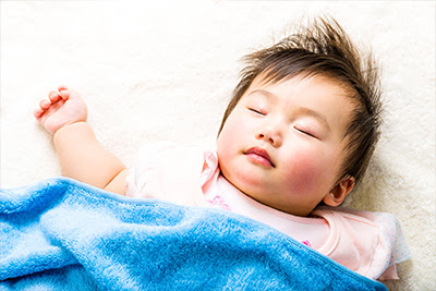 Baby girl sleeping with a blue blanket