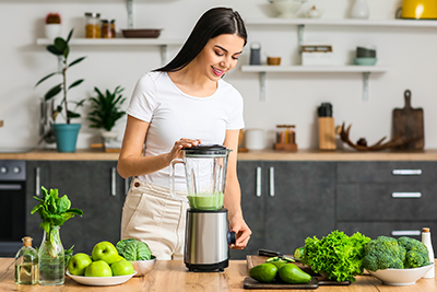 Woman making green smoothie to boost fertility